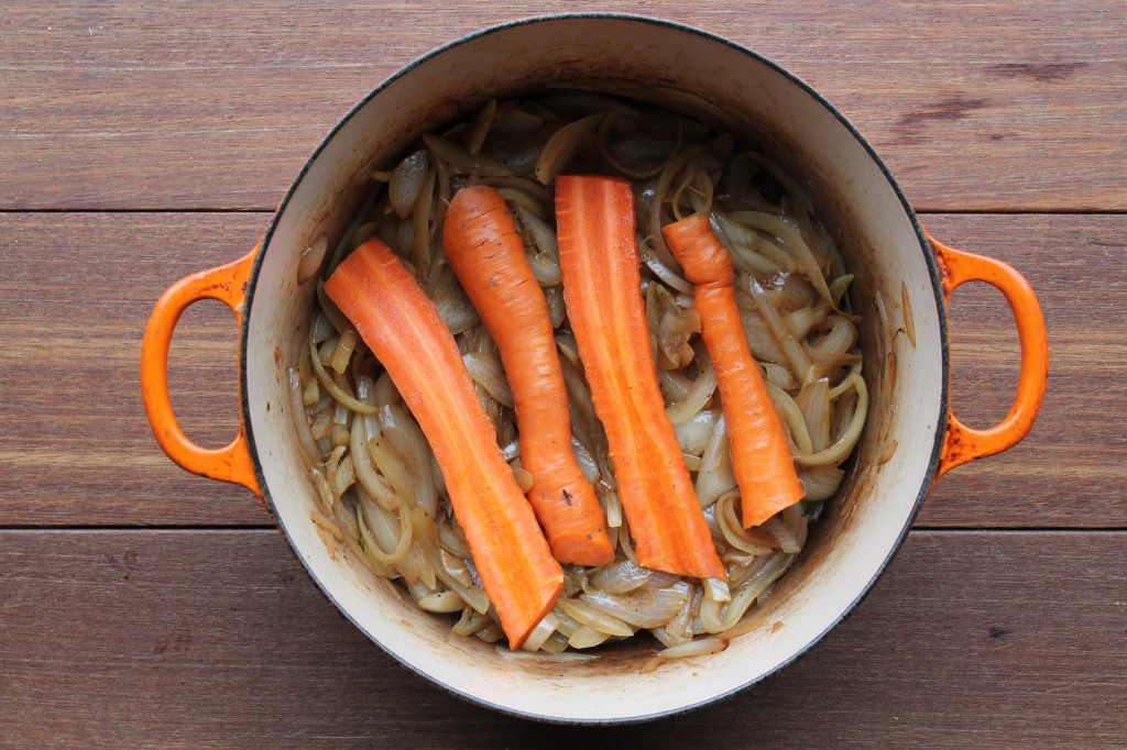 Into the dutch oven goes almost caramelized onions, a few carrots... 